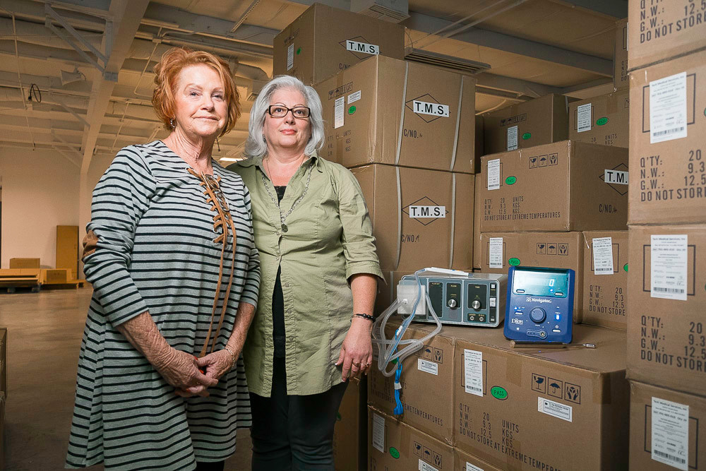 DETECTIVE TECHNOLOGIES: Paulett Anderson, left, and LeAnn McKee stand beside boxes of products. One, the MBI camera, boasts a 97 percent negative predictive value for detecting cancer.