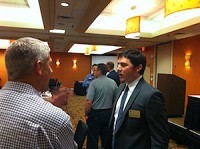 Charles Gascon, an economist and senior research support coordinator with the Fed in St. Louis, speaks with one of 120 SBDC meeting attendees yesterday at the DoubleTree Hotel.SBJ photo by BRIAN BROWN