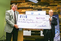 RMI CEO Ken Lueckenotte presents a $150,000 check to Missouri State University President Clif Smart for The eFactory&rsquo;s business accelerator program and seed capital fund.SBJ photo by GEOFF PICKLE