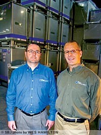 Custom Metalcraft International Sales Manager Greg Macchi, left, and TranStore Division General Manager Scott Higgins stand in a group of TranStore intermediate bulk containers. The Springfield manufacturing company sold $3 million in exports in 2011.