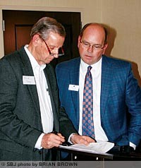 David Myers, right, of The Whitlock Co., discusses tax issues with Frank Corry, who attended an educational forum on "fiscal cliff" and health care concerns Nov. 27 at the Hilton Garden Inn.