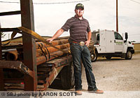 Eli Long readies a load of metal pipe for fencing outside his 5,000-square-foot office and warehouse in Ozark.