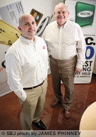 Derron Winfrey, left, and his father, Dennis, are growing Electronic Check Services by focusing on sales of prepaid cards, including cellular service, bill pay and gift cards.