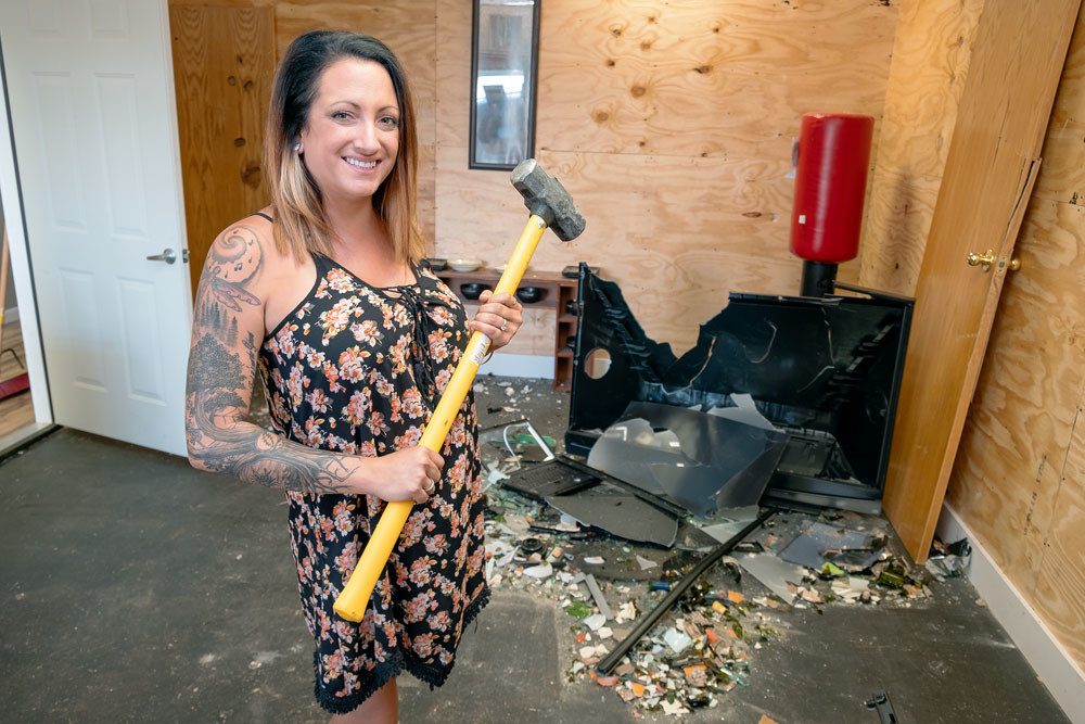 RATHER SMASHING: The Rage Room co-owner Brittany Yarnton wields a sledgehammer, one of the weapons of choice that customers can use to break objects for entertainment or stress relief.
