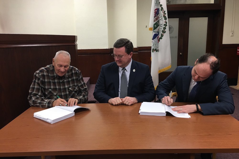 Commissioners Harold Bengsch, Bob Dixon and John Russell sign the annual budget.