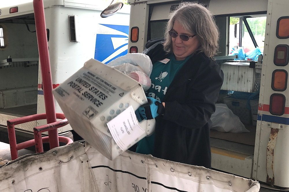 Bonnie Schooler, executive director of the Least of These Inc. food pantry, gathers donations from the Stamp Out Hunger event.