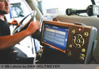 Justin Kenall installs a QualComm electronic logging system in a truck for Prime Inc., which has equipped its 4,000-truck fleet with e-log technology.