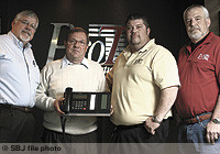Protel founder Steve Thompson, second from left, has completed the sale of his business to employees, from left, Bruce Jones, Shane Taylor and Randy Harris.