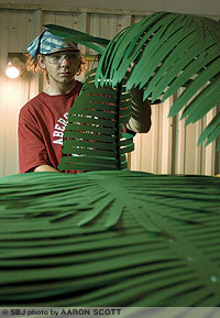 Tropical Palm Trees employee Chris Groves puts a completed palm frond on the pile. Fronds range in length from 10 feet to 16 feet.