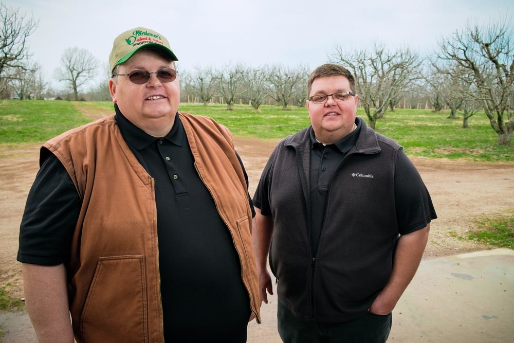 FAMILY FARM: Cornelius Gradinariu, left, fled Romania and ultimately settled at a Brighton orchard, where his son Radu, right, works as an account manager.