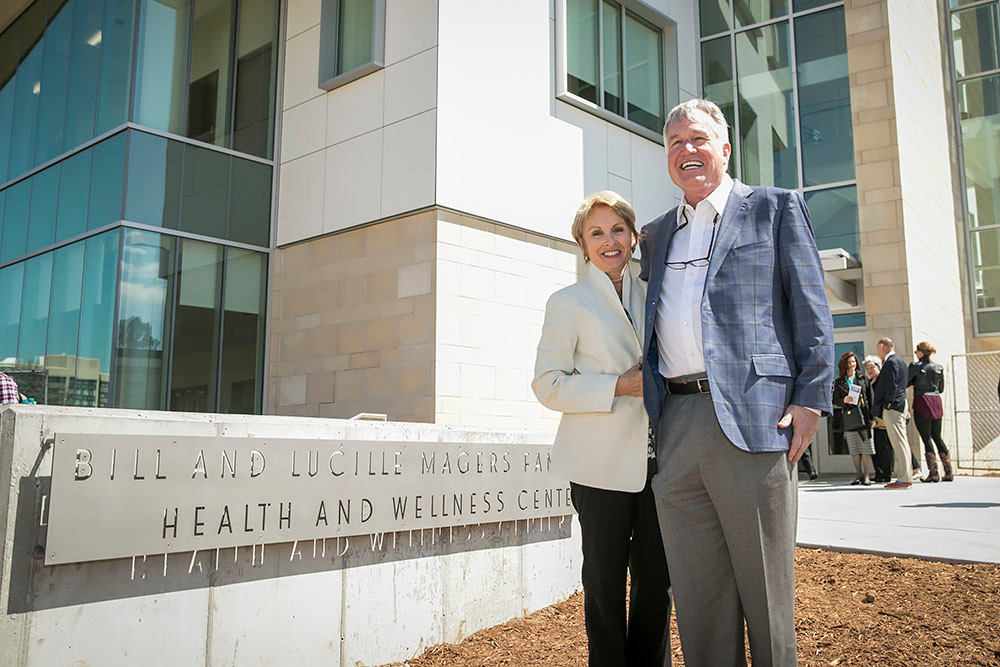 Magers and his wife Chris pose next to the center's recently changed signage.