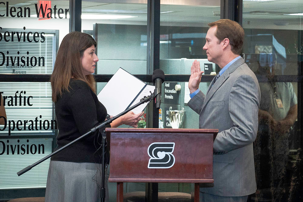 City Clerk Anita Cotter administers the oath of office this morning to new city manager Jason Gage.