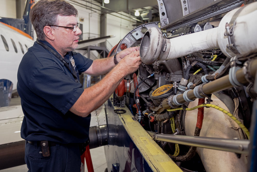 Dave Powell, shop manager, works on an engine in the hangar of Worldwide Aircraft Services.