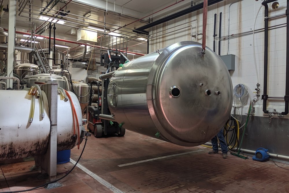 Crews install a new fermenting tank at Mother’s Brewing Co.
