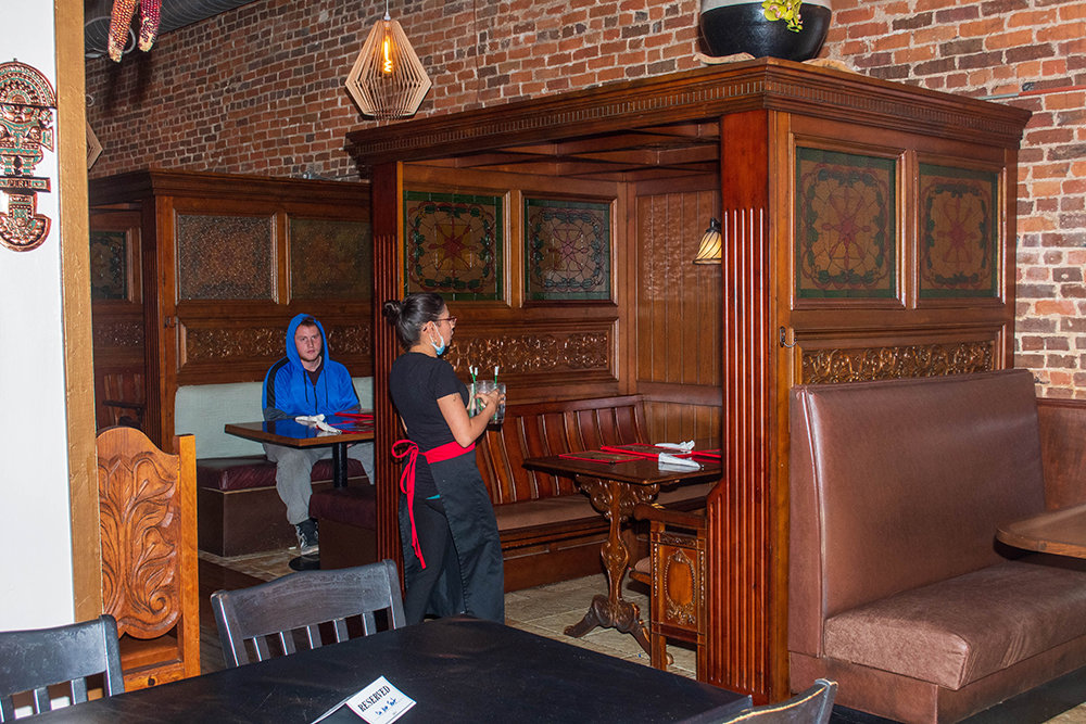 A server at Cafe Cusco prepares a table for guests on the restaurant's first night reopened.