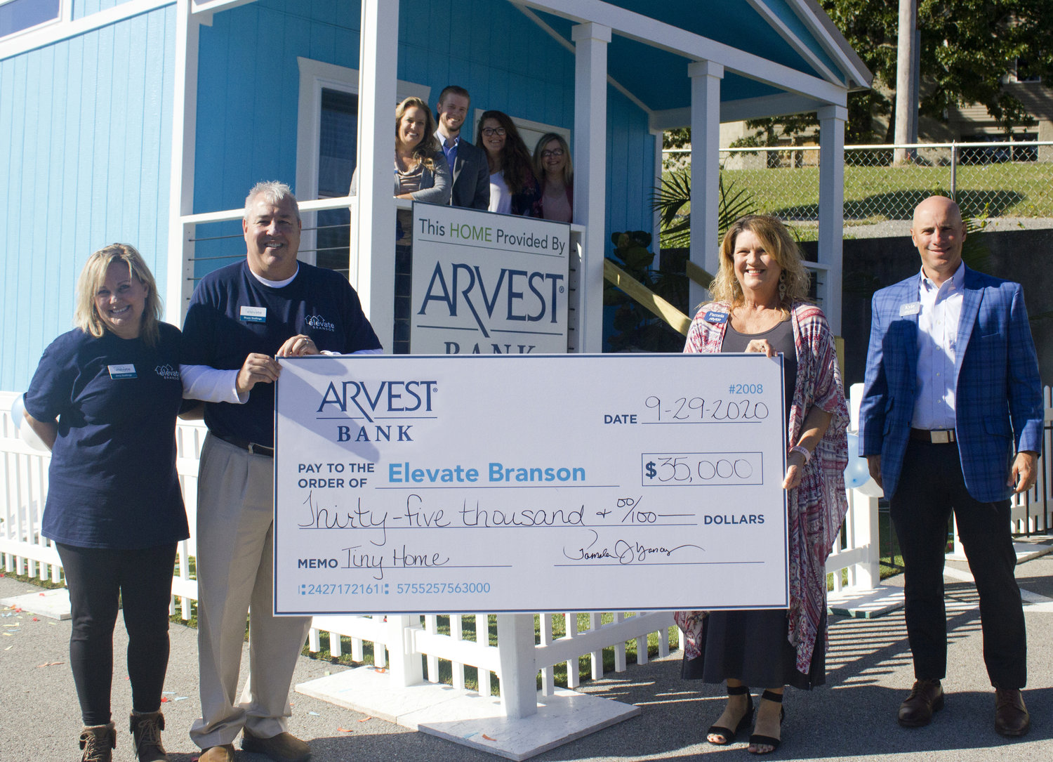 Arvest Bank officials present a $35,000 check to Elevate Branson for its tiny homes community.