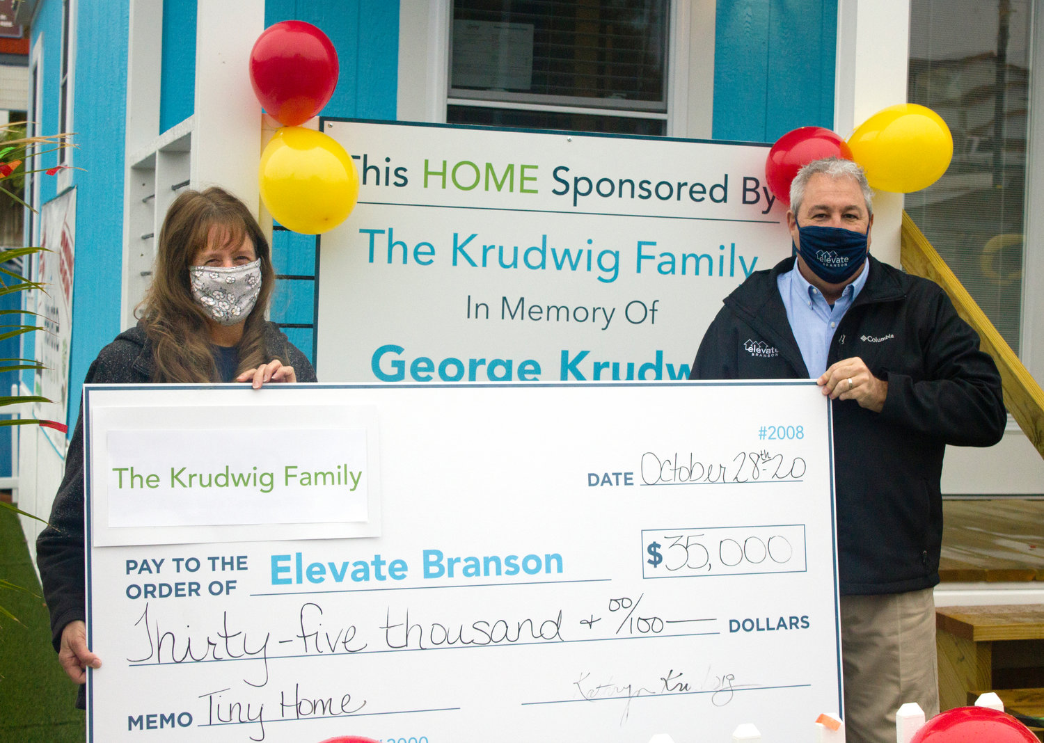 Kathy Krudwig presents a check to Elevate Branson founder Bryan Stallings.