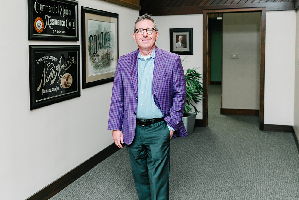 Richard Ollis is a fourth-generation owner of Ollis/Akers/Arney and he plans to remain independent. His great-grandfather, pictured on the far wall, founded the firm.