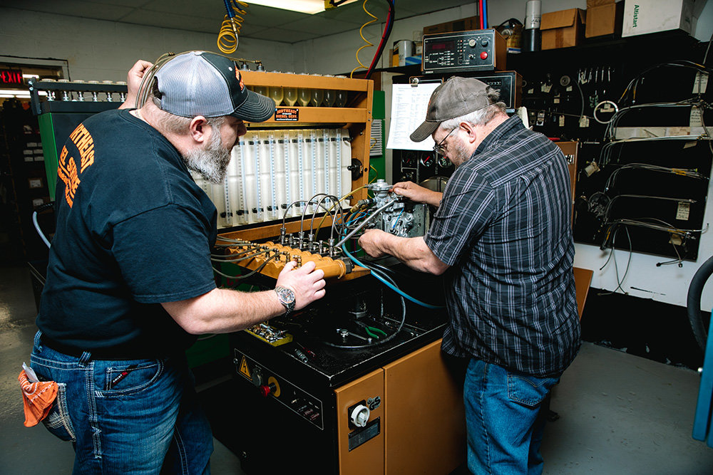 ENGINE MAVENS: Northeast Diesel Service of Springfield Inc.'s Mike Glover, left, and Rick "Cooter" Perrigo make fuel injection repairs at the company's East Division Street shop.