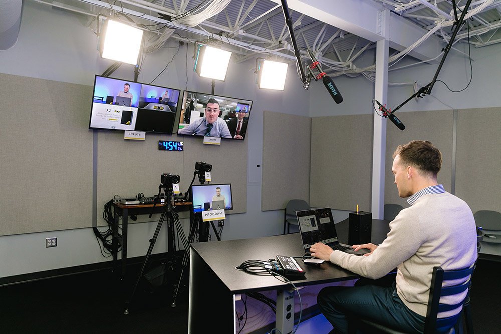 Quinton Booth, sales specialist with Digital Monitoring Products, uses the company's new videoconferencing studio.