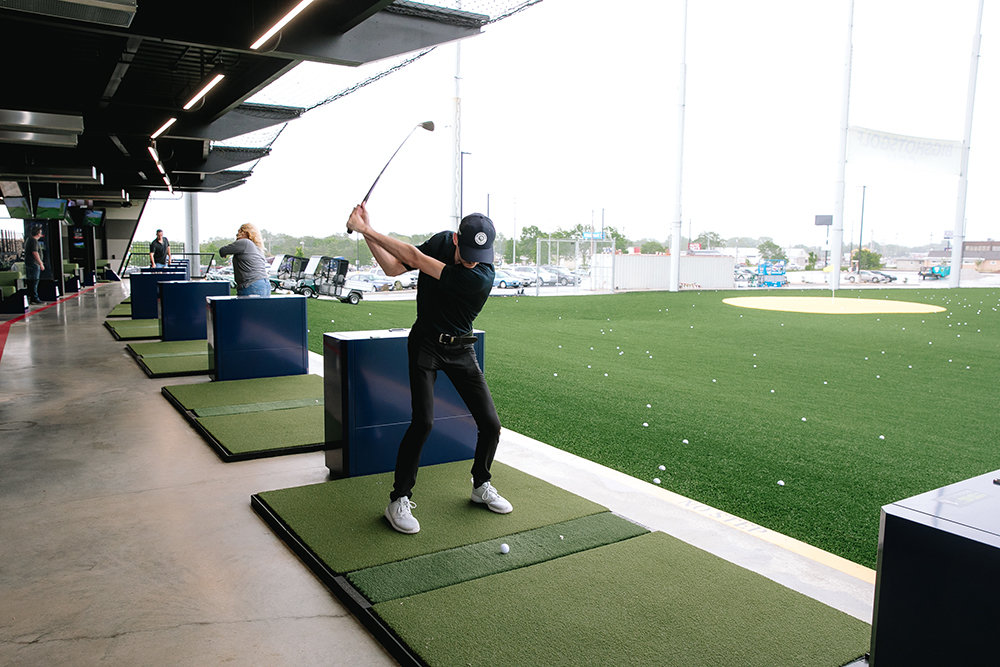 A BigShots Golf staffer tees off at the north-side attraction.