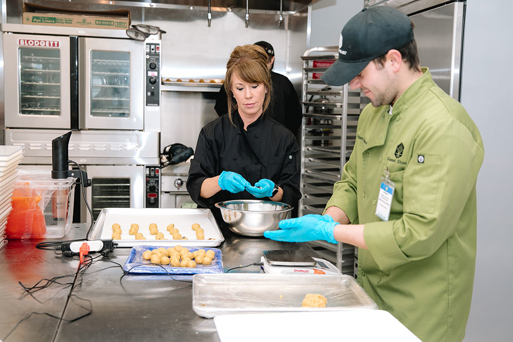 PRODUCT PREPARATION: Heartland Labs employees Janette DeGood and Adam DeGood prepare a new batch of cannabis-infused cookies for the oven.