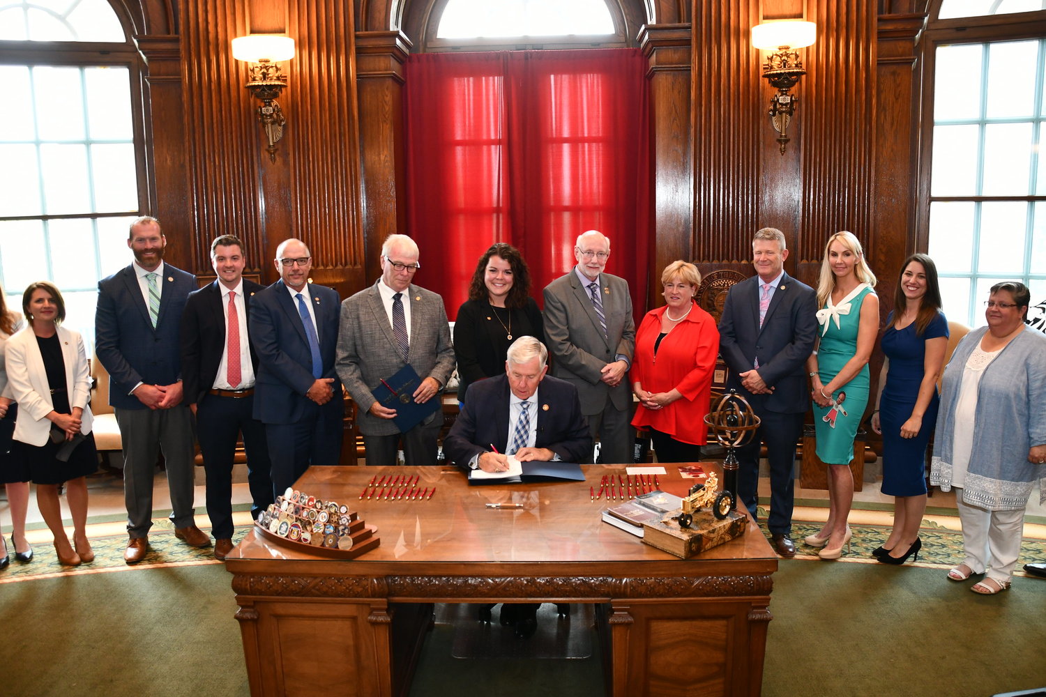 Gov. Mike Parson signs legislation supported by Rep. Crystal Quade, second from right.