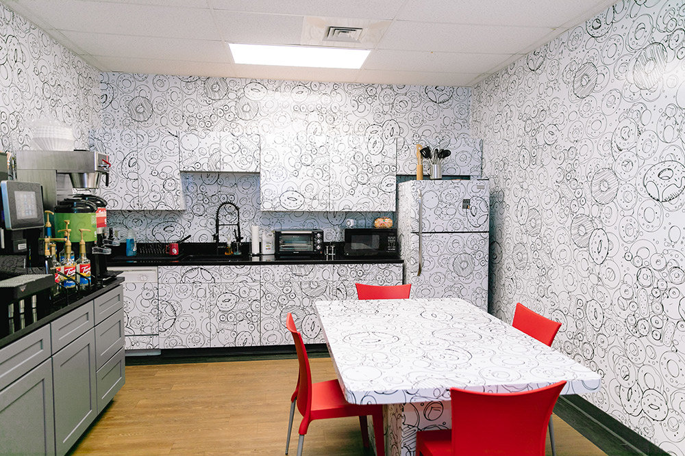 Hurts Donut’s break room is decked out floor to ceiling with – surprise – doughnuts. The fun starts here, as the coloring book-style walls and table can be personalized with dry erase markers. Visitors may not see the exact same design in this room twice. As with other areas in the office, the vinyl paneling was designed and printed in-house.