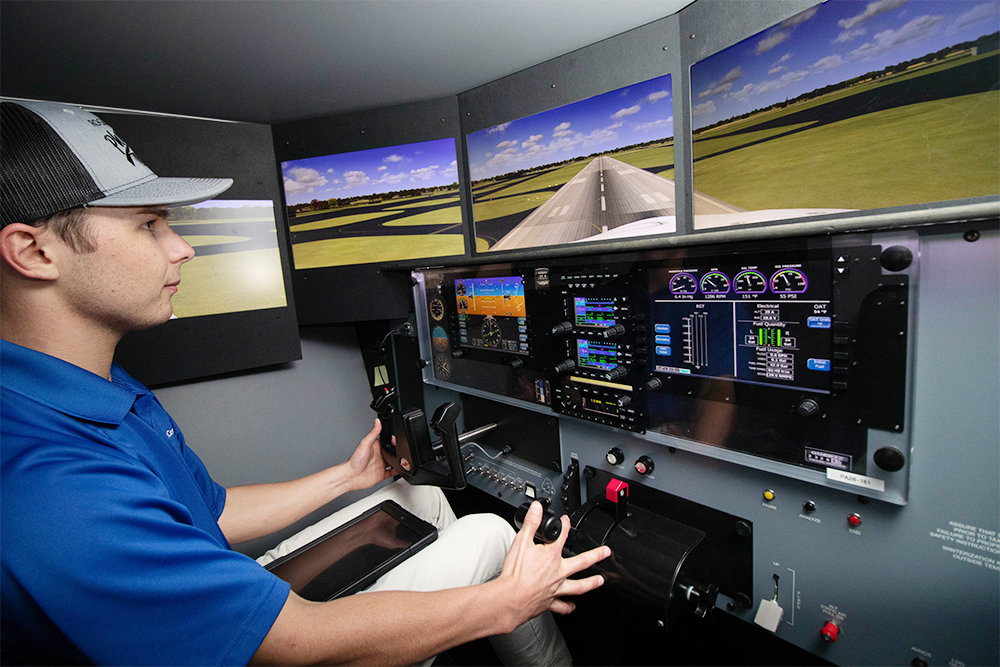 Alex Shaw, certified flight instructor for Premier Flight Center, Demonstrates simulation technology used for training.