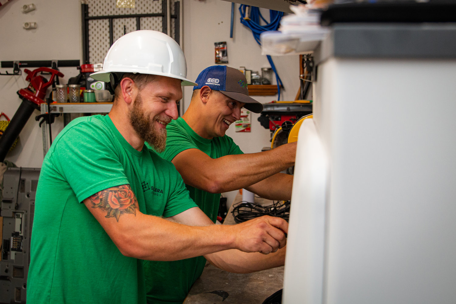 Solera Energy's Josh Calvin, left, and Tyler Kahler check the connections for a solar inverter.
