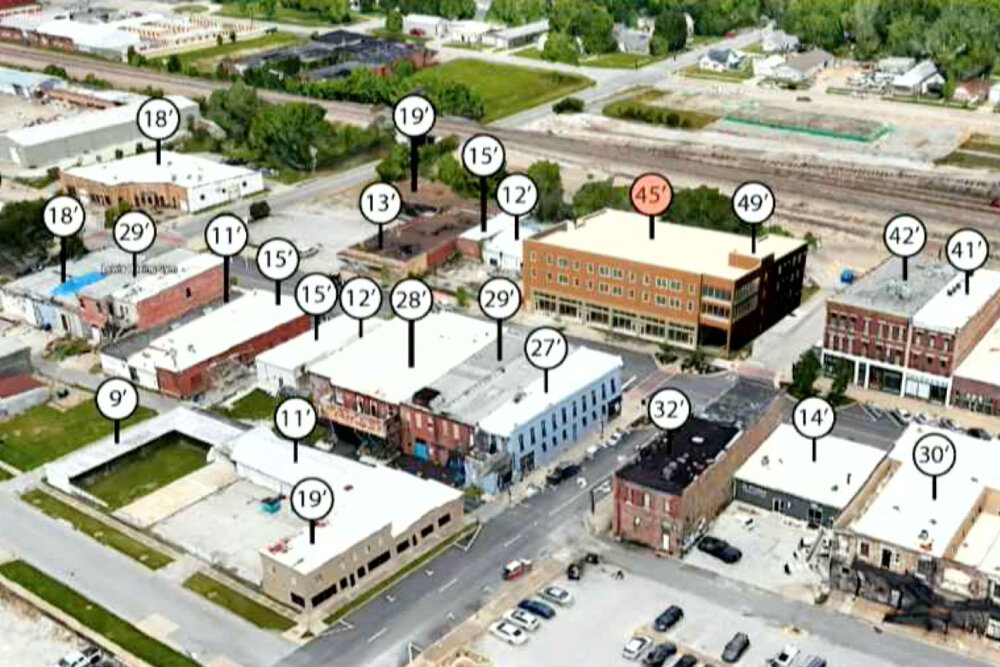 An artist’s rendering shows the comparative height of a proposed four-story apartment building, marked with a red circle at the top center, proposed by The Vecino Group on C-Street. 