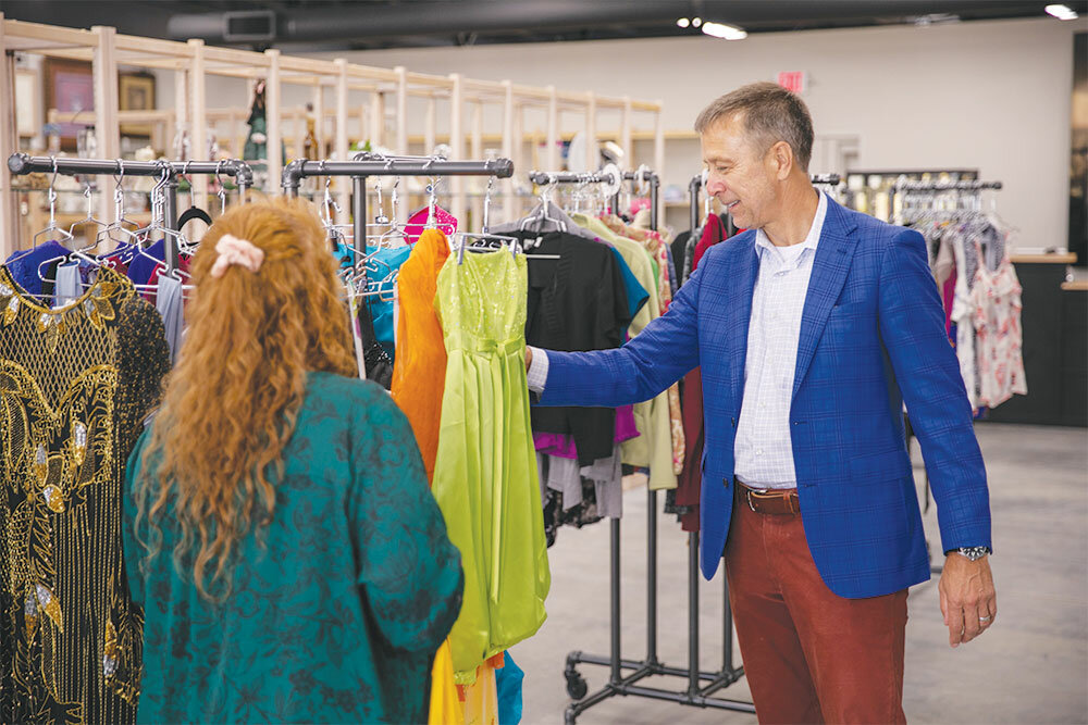 Manager Amy Hobson shows Joe Daues some of the new inventory at Neat Repeats. Options range from formal wear to sports gear.