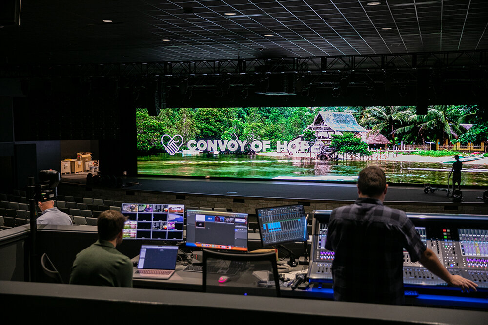 Convoy of Hope staff discuss audio and video in the auditorium while preparing for the Oct. 5 dedication event.