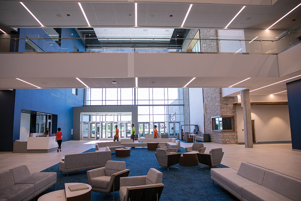 An atrium with ample seating and a wall of windows bringing in natural light awaits visitors at the headquarters.
