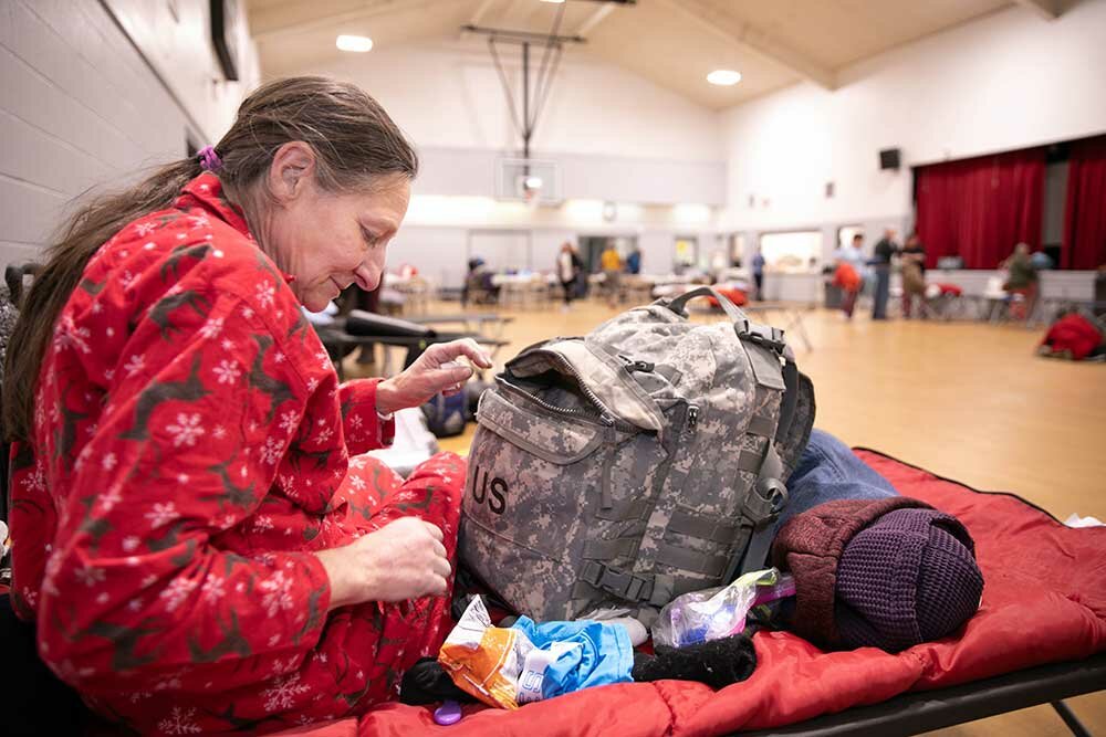 SAFE TO SLEEP: Barbara Smith settles in for the night in the church gym that functions as the Safe to Sleep women's shelter of Council of Churches of the Ozarks.